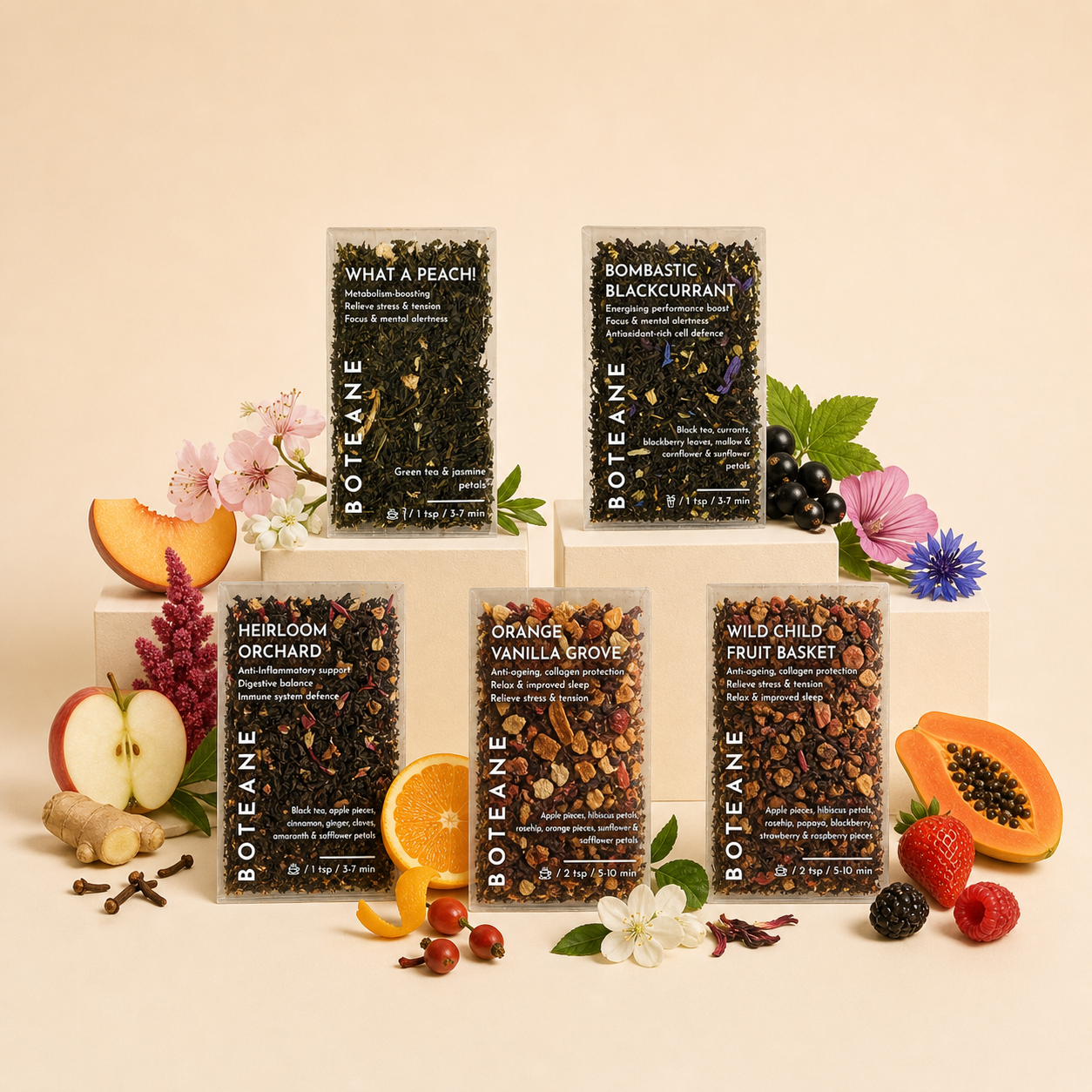 Boteane's Fruity Box — five loose-leaf fruit tea blends arranged on a warm beige background with fresh fruit and flowers
