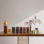 Boteane products on a wooden table with glasses of tea and a vase with dried plants.
