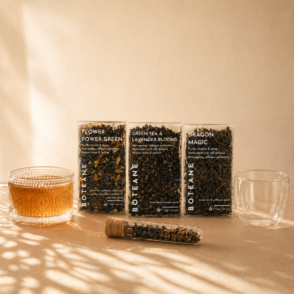 Three boxes of Botteane tea with a glass of tea and a capsule on a light surface.