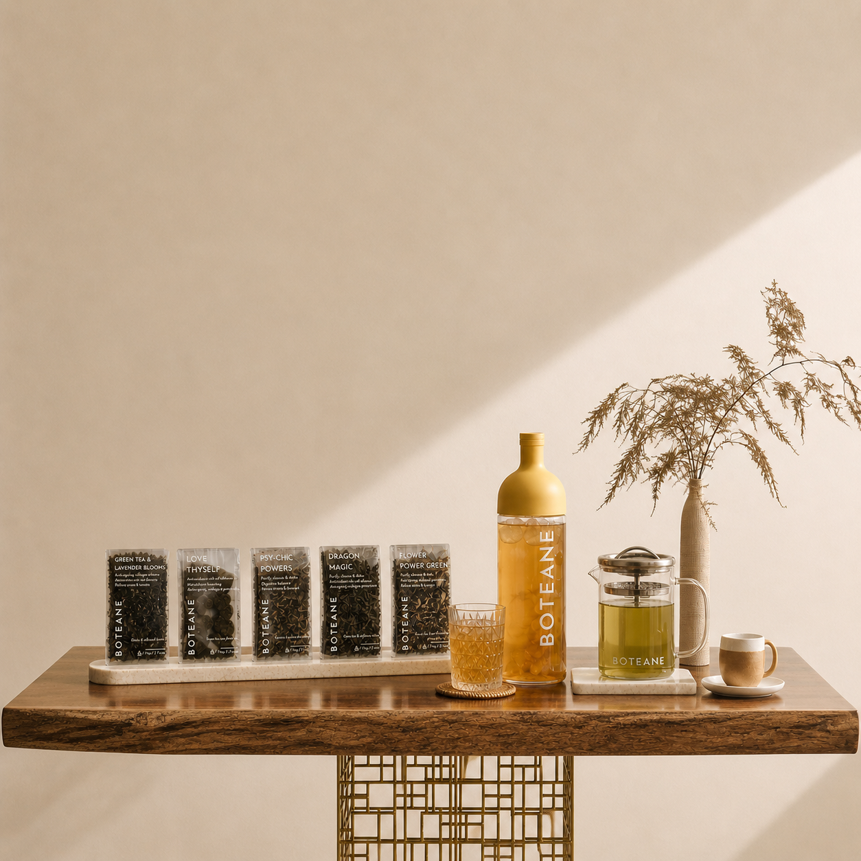 Table with Botane products including a bottle, jars, and a glass on a neutral background