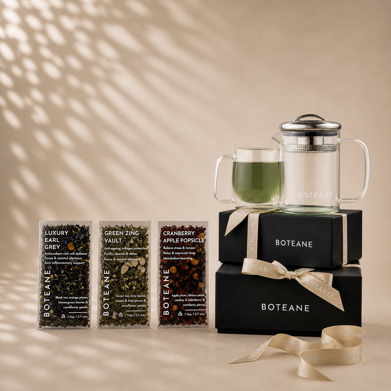 Boteane tea packaging with a black box, glass mug, and teapot on a beige background